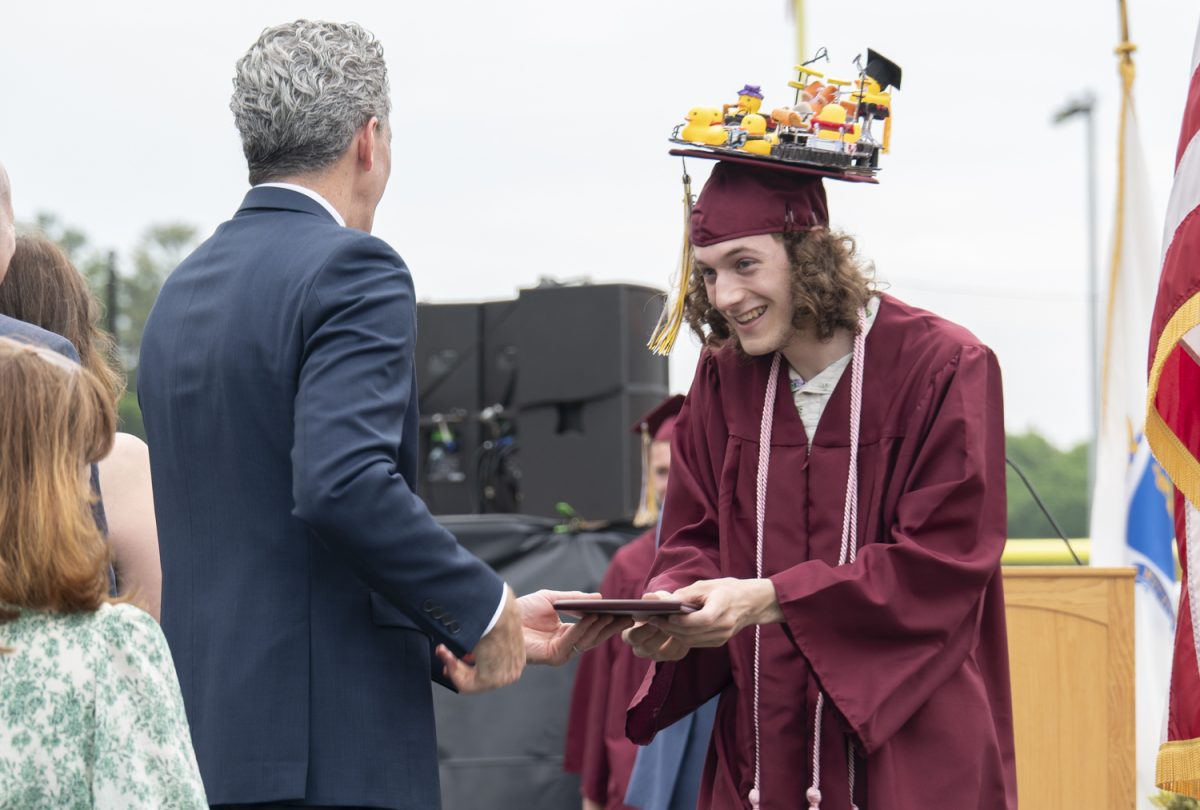 Senior Thomas Schuler attempts to keep his graduation cap balances while accepting his diploma at graduation on June 6.