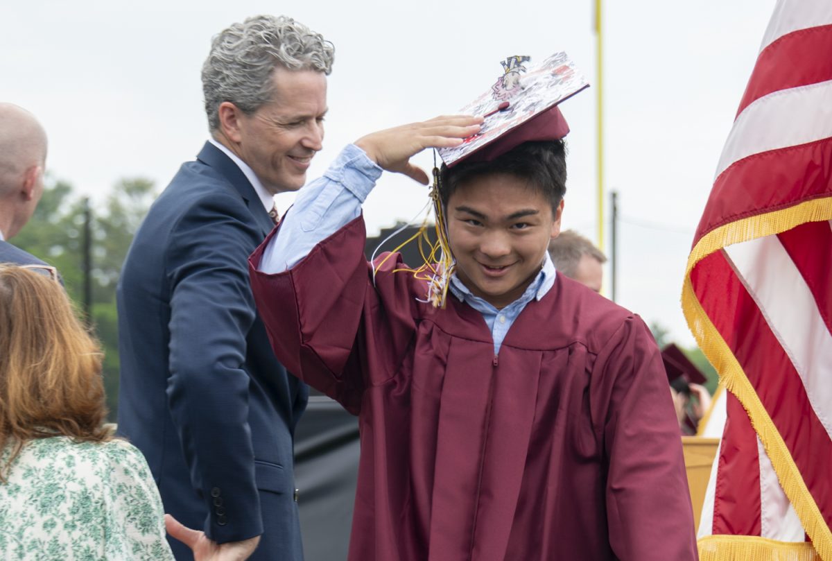 Senior Jaxson Kwan accepts his diploma after doing a flip on stage during graduation on June 6.